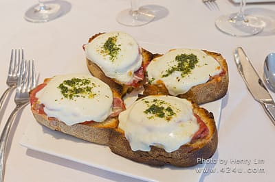 Toasted bread topped with melted cheese and green herbs
