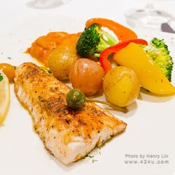 A fish fillet with small potatoes, peppers and broccoli